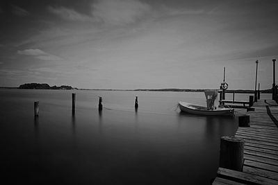 Boats moored at harbor against sky
