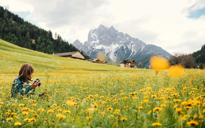 Rear view of woman on field against cloudy sky