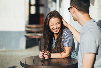 Smiling young couple sitting at cafe