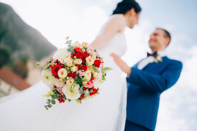 Low angle view of people holding flower bouquet