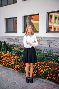 A teenager is standing near the school. preparing for school