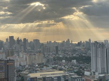 Modern buildings in city against sky during sunset