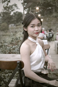 Portrait of young woman sitting on chair