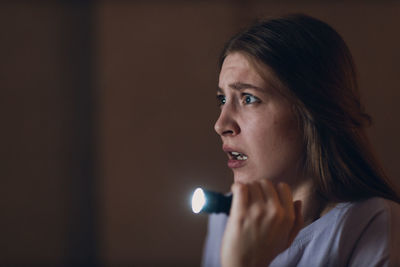 Close-up of young woman looking away at home