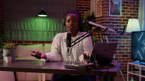 Portrait of young woman using laptop while sitting on table