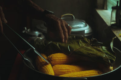 Close-up of person preparing food or corn