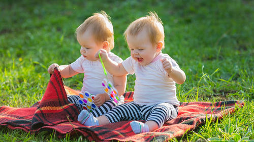 Siblings sitting on lawn