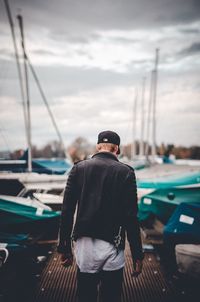 Rear view of a man with umbrella standing in background