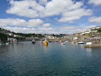 Boats moored at harbor against sky