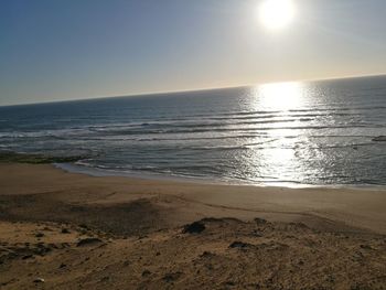 Scenic view of beach against clear sky during sunset