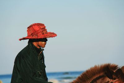 Side view of man horseback riding against clear sky