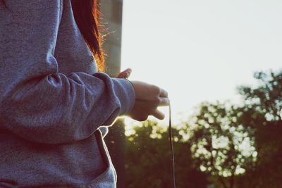 Midsection of woman standing against sky