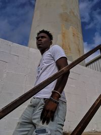 Low angle view of young man standing against sky