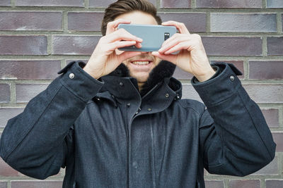 Full length portrait of man photographing