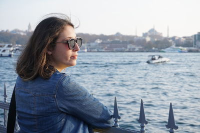 Woman looking at river in city