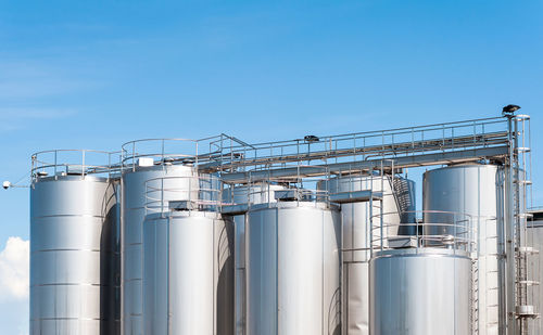 Low angle view of factory against clear blue sky