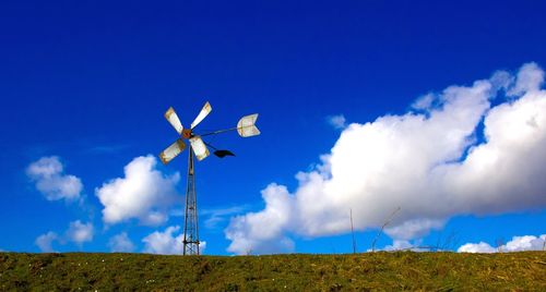 Low angle view of wind turbines on landscape