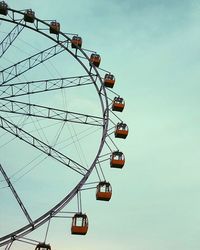 Low angle view of ferris wheel against blue sky