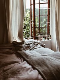 Close-up of bed by window at home