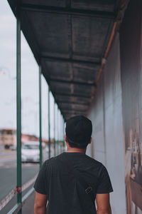 Rear view of man standing on bridge