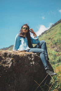 Young woman sitting on rock