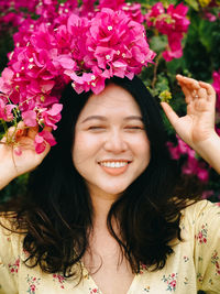 Portrait of smiling woman with pink flower