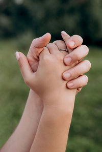 Clasped hands of woman outdoors