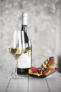 Wineglass and bottle with fruits on floor