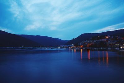 Scenic view of lake against sky in city