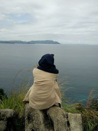 Rear view of woman looking at sea against sky