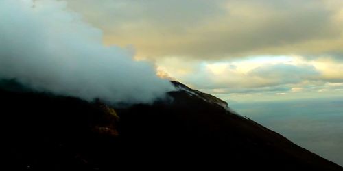 Low angle view of volcanic mountain against sky during sunset