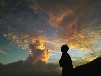 Silhouette of man against sunset sky