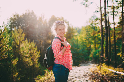 Young woman standing amidst trees
