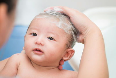 Close-up of shirtless boy holding baby