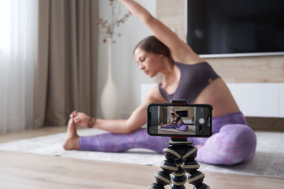 Young woman photographing with camera on table