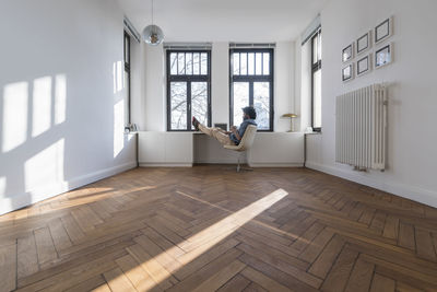 Man sitting in minimalist empty room on chair