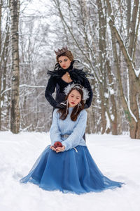 Portrait of young woman standing in snow