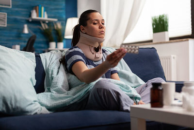 Full length of woman sitting on bed