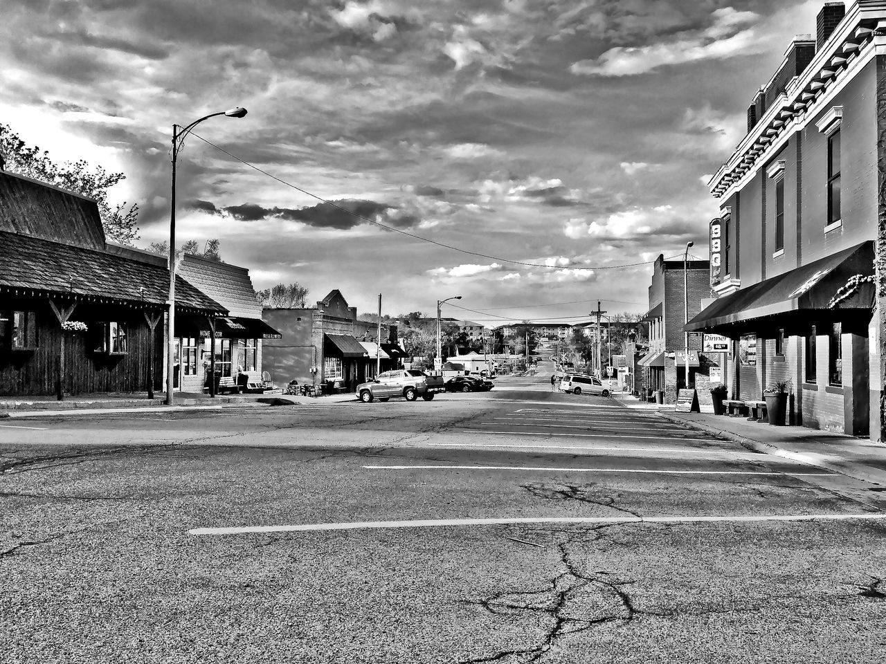 VIEW OF CITY STREET AGAINST CLOUDY SKY