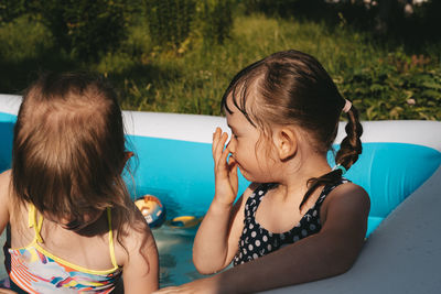 Children playing in the pool. friends spend summer leisure together on a hot day