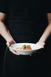 Midsection of man holding ice cream in plate