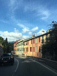 Road by trees against sky