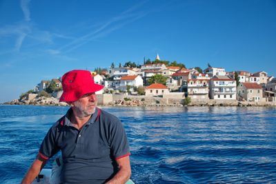 Man standing on sea against blue sky