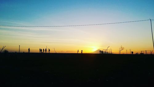Scenic view of silhouette field against sky during sunset
