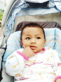 Cute baby girl lying in stroller