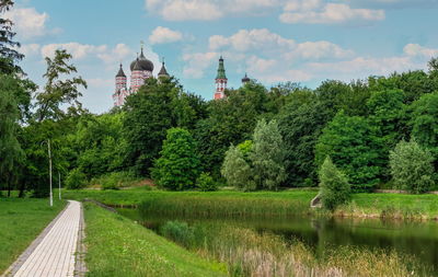 Scenic view of trees by lake against sky