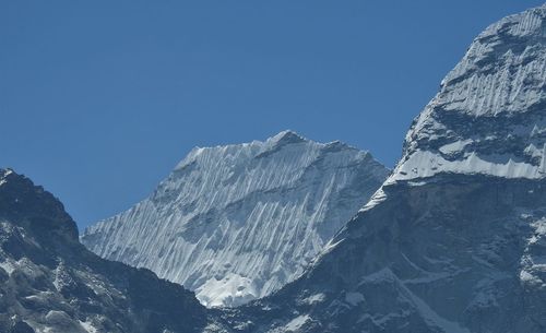 Scenic view of snowcapped mountains against clear blue sky