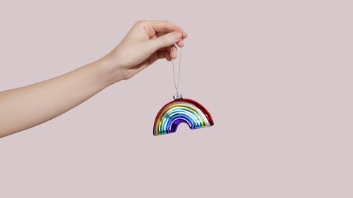 Cropped hand of woman holding key against white background