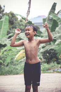 Full length of shirtless boy standing outdoors