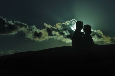 Silhouette of person against cloudy sky